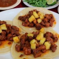 Al Pastor · 3 mini tacos filled with marinated Caribbean flavored pork, cilantro, diced onions, and pine...