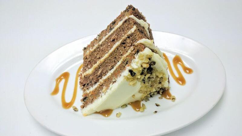 Slice Of Carrot Cake · Four layers of our carrot cake filled with our cream cheese frosting.