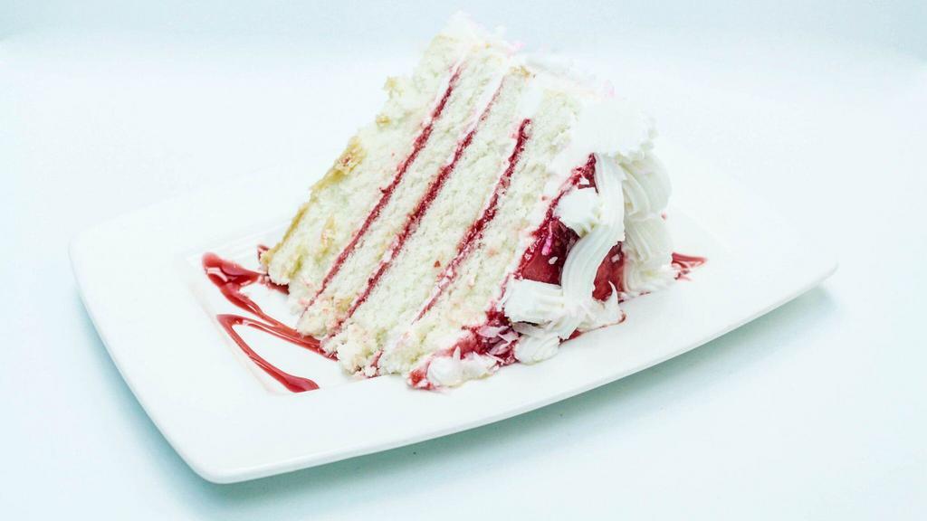 Slice Of Raspberry Coconut · Four layers of white cake filled with raspberry  filling and finished and frosted with coconut frosting and  coconut flakes.