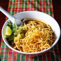 Khao Soi · Thai northern style yellow curry noodle soup with coconut milk, egg noodles, and garnishes w...
