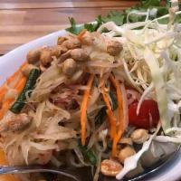 Thai Papaya Salad · Salad with a papaya with lime juice, cherries tomatoes, slice carrots, topped with peanuts.
