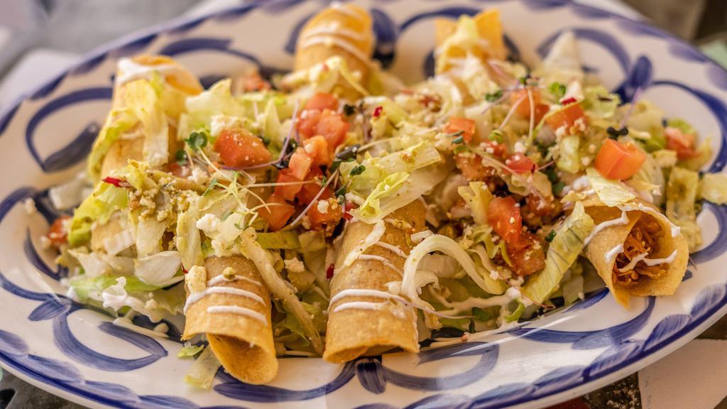 Flautas Regias · Three pieces. Roasted chicken flautas in corn tortillas, queso fresco, sour cream, pico de gallo, lettuce, and a side of cilantro lime sauce.