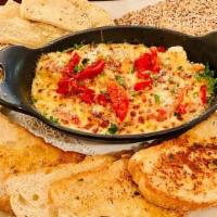 Oven-Baked Artichoke Dip (V) · With sun-dried tomatoes and parmesan served with garlic bread, flatbread & crackers.