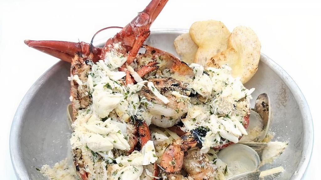 Lobster Tchoupitoulas · Whole grilled lobster with clams, shrimp, lump crab meat and linguini topped with garlic butter and parmesan.