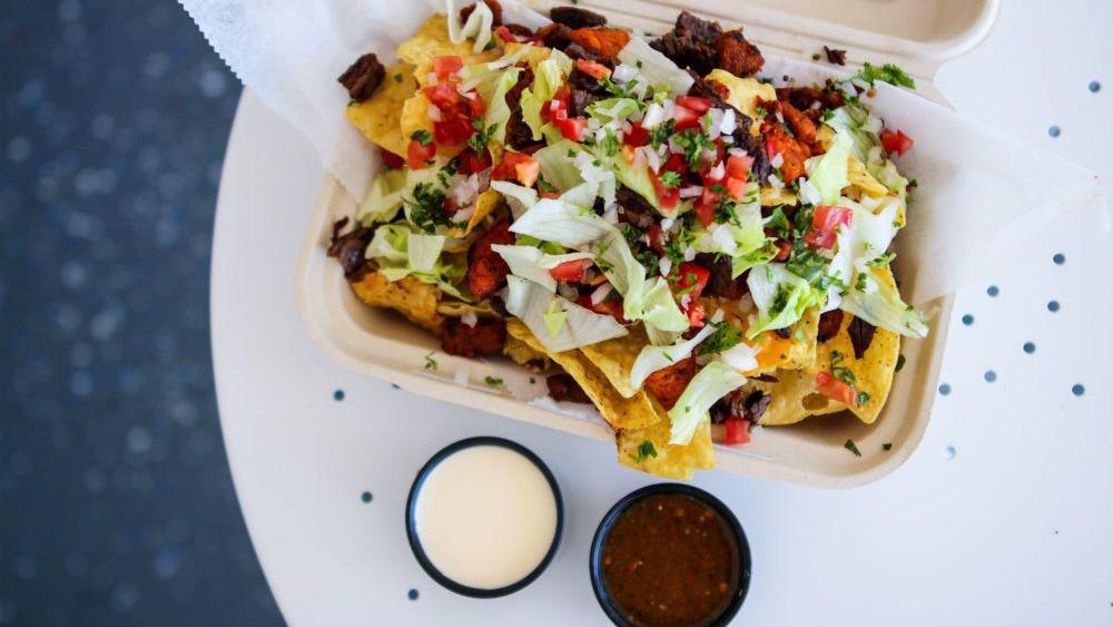 Nachos With Carnitas · A large pile of corn tortilla chips, carnitas, beans, and cheese sauce. Served with a side of homemade salsa and crema. Add guacamole for an additional charge.