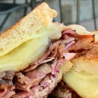 Ruebenesque Sandwich · Sautéed navel pastrami, melted swiss cheese, caramelized red onions, house slaw and hot sauc...