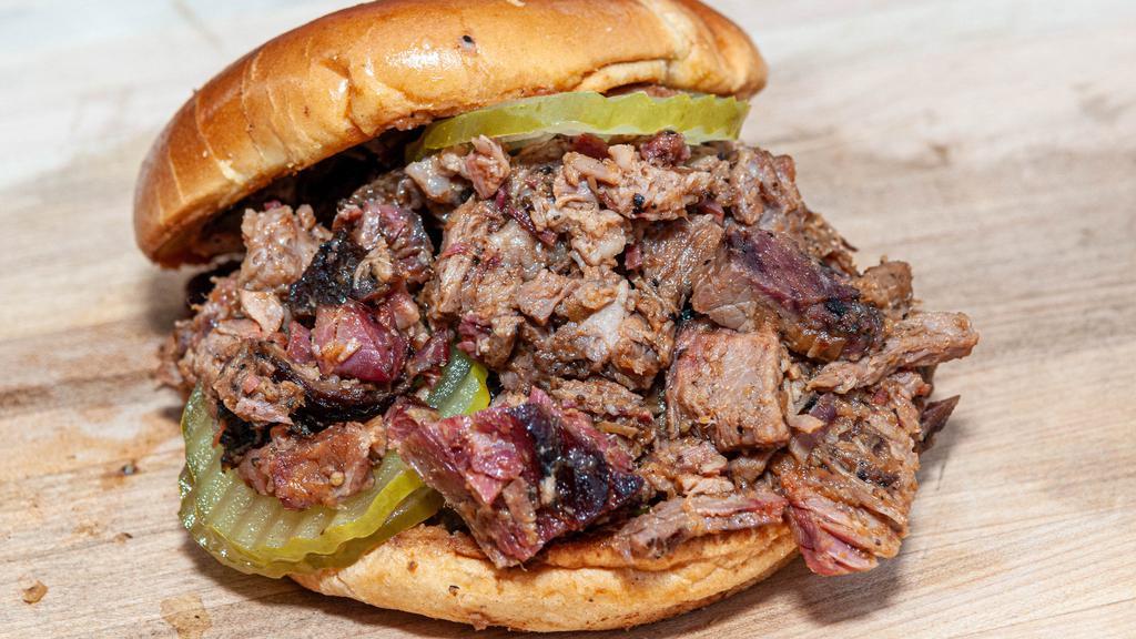 Chopped Brisket Sandwich · Our delicious prime slow smoked brisket chopped, and tossed in our beer BBQ sauce. Topped with pickles and onions.