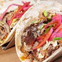 Pulled Pork Tacos · Two flour tortillas stuffed with tender juicy smoked pulled pork, topped with slaw and beer ...