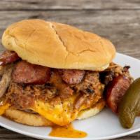 Pitmaster Burger · 1/3 lb patty, mustard, pickles, chopped brisket, pulled pork, sausage, and beer BBQ sauce.