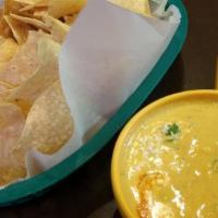 Chips & Queso · Homemade chips with roasted salsa queso topped with queso fresco, cilantro and habanero sauce.