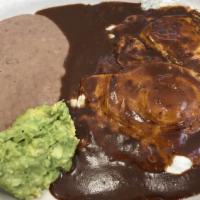 Huevos Con Mole · Two eggs covered with mole sauce on a sincronizada. Served with refried beans, fresco cheese...