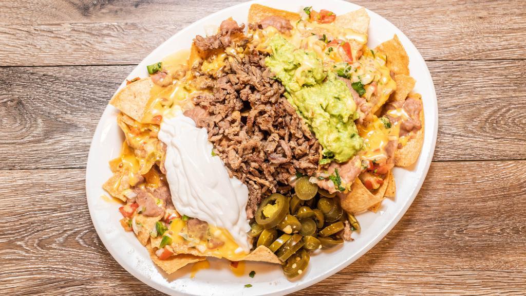 Nachos Omg · Tortilla chips topped with chile con queso, refried beans, pico de gallo, jalapenos, sour cream, guacamole, and choice of meat.
