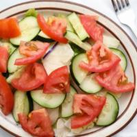 Cucumber Salad · Diced cucumbers, red onions, iceberg lettuce and tomatoes.