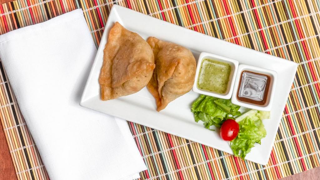 Samosa · Vegetable turnovers stuffed with potatoes and green peas, tempered with cumin seeds and spices.