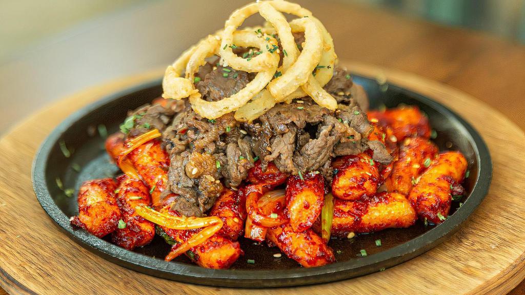 Spicy Rice Cake With Beef (Gf) · stir-fried rice cakes with a sweet and spicy chili sauce topped with marinated beef brisket