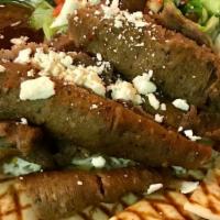 Gyro Platter · Tender beef and lamb gyro meat on a bed of basmati rice, served with salad, grilled pita bre...