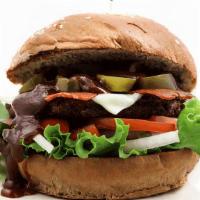 Texas Burger · Homemade soy patty, lettuce, tomatoes, onions, cheese, vegan bacon, BBQ sauce & pickled jala...