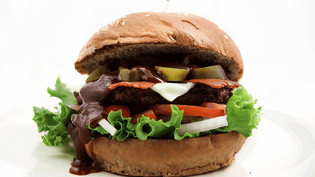 Texas Burger · Homemade soy patty, lettuce, tomatoes, onions, cheese, vegan bacon, BBQ sauce & pickled jalapeños. (NF) Our burger patty is made with wheat flour so it cannot be made gluten free. The vegan bacon strips are made from soy & wheat protein.