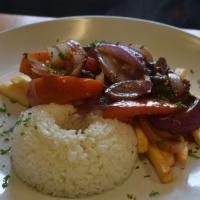 Lomo Saltado · Sautéed flank steak with onions, tomatoes and cilantro over French fries. Served with rice.