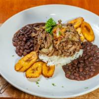 Ropa Vieja Dinner · Beef brisket slowly simmered, sautéed with onions, tomatoes and parsley. Served with rice, b...