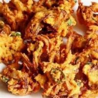 Onion Pakora · Deep fried battered sliced onion fritters. Served with sides of mint and tamarind/date chutn...