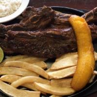 Costilla De Res · Asado de Tira. 2 short ribs marinated Sazon style, served with French fries, plantain, and r...