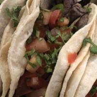 Tacos De Carnitas (Pork) · Three soft corn tacos with pork. Served with rice, beans, pico de gallo and guacamole on the...