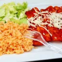 Enchiladas Poblanas · Three Chicken enchiladas with traditional mole poblano (dark red sauce) mixed with red peppe...