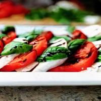 Mozzarella Caprese · Fresh mozzarella cheese over tomatoes with olive oil, fresh basil, and a balsamic glaze.