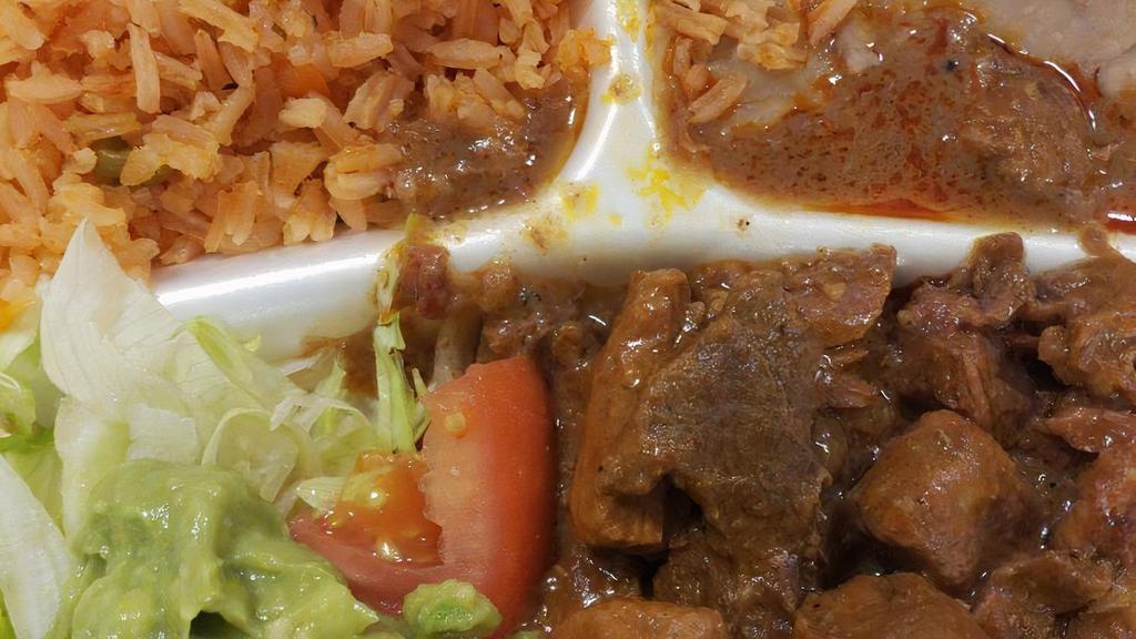 Carne Guisada · Beef gravy, rice, beans, lettuce, tomato & guacamole.