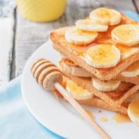 Banana French Toast · Sliced challah bread soaked in eggs and milk, then fried and topped with bananas, served wit...