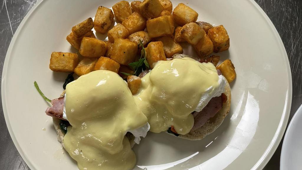 Country Benedict · Two poach eggs, ham steak, bacon, diced tomatoes & spinach on an English muffin topped with hollandaise sauce, served with home fries.