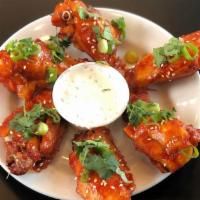 Korean Chicken Wings · Tangy, spicy, delicious, and very Korean. Served with scallions, toasted sesame seeds, and c...