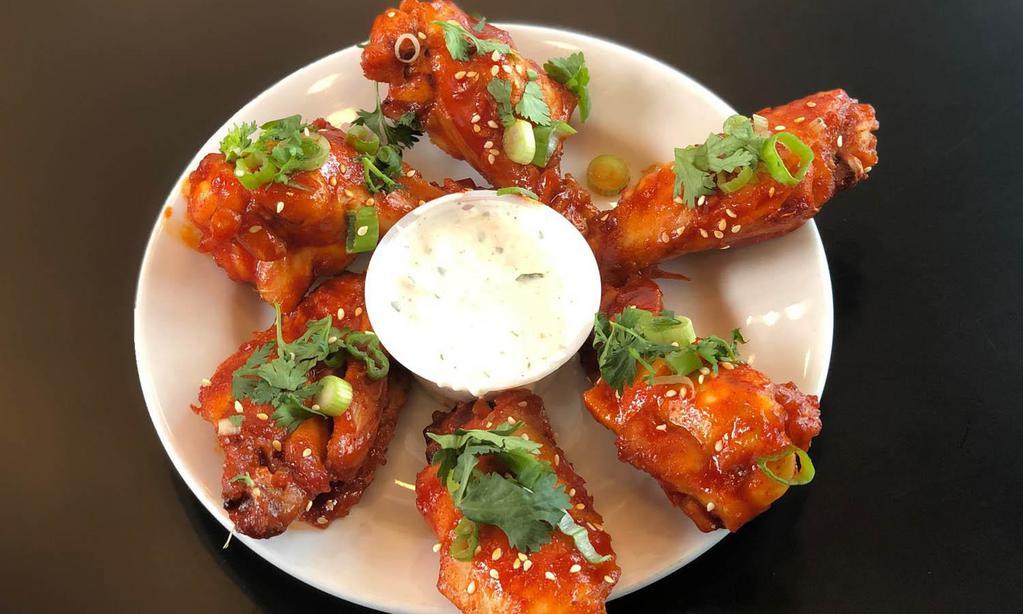Korean Chicken Wings · Tangy, spicy, delicious, and very Korean. Served with scallions, toasted sesame seeds, and cilantro, and lemon blue cheese dip.