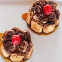 Tiramisu · single serving mini tiramisu pastries decorated with ladyfingers, a raspberry, and cocoa pow...