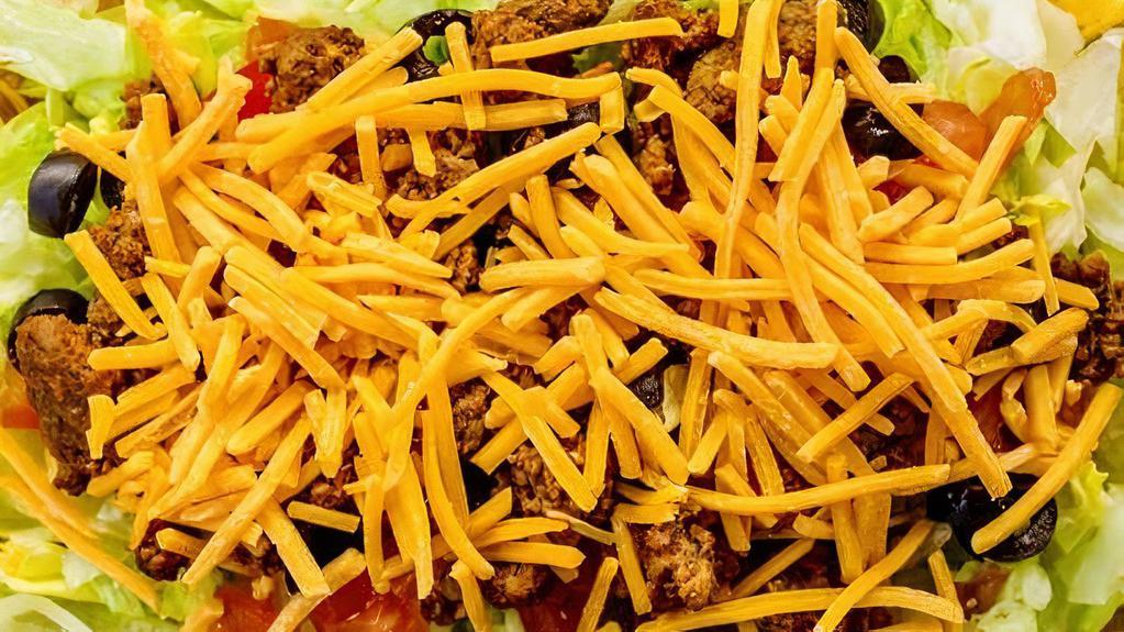 Taco Salad · Gluten free. Iceberg lettuce topped with seasoned ground beef, Cheddar cheese, tomatoes, and black olives served with salsa, tortilla chips and the dressing.