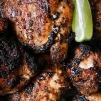 Jerked Chicken (Legs & Thighs) · Charcoal grilled jerk chicken leg quarters, marinated in our jerk seasoning (cut in sections...