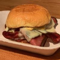 Fried Bologna · Fried bologna, American cheese, mustard sauce, and pickles on a Martin's Potato roll.