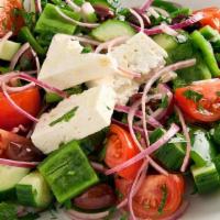 Greek Salad · Dolmadakia, feta and olives over greens.