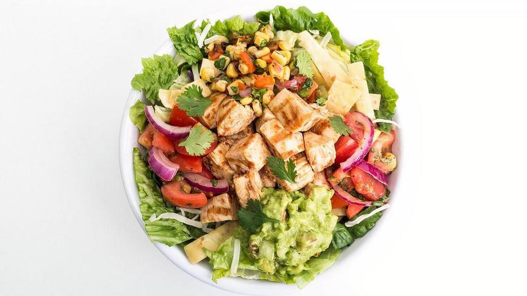 Southwest Mesquite Chicken Salad · Grilled mesquite chicken served on top of crisp greens with Jack cheese, guacamole, fiesta tomatoes, fire roasted corn salsa, crunchy tortilla crisps and cilantro.