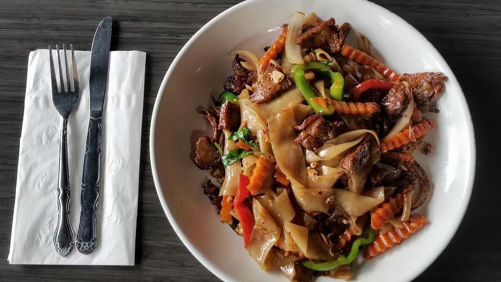 Spicy Noodle · Vegan, gluten free, spicy. Our most popular wide rice noodle sautéed in a mixture of onions, bell peppers, carrots, and fresh basil in our famous chili garlic sauce.