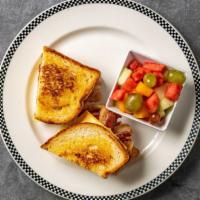 Breakfast Sandwich · Hash Brown patty, cheese, egg, and choice of meat, on a toasted sourdough bread. Fruit on th...