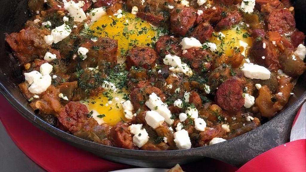 Shashuka Tajine · Merguez beef sausage, Roasted Bell pepper and tomato sauce, Three sunny eggs, feta cheese.