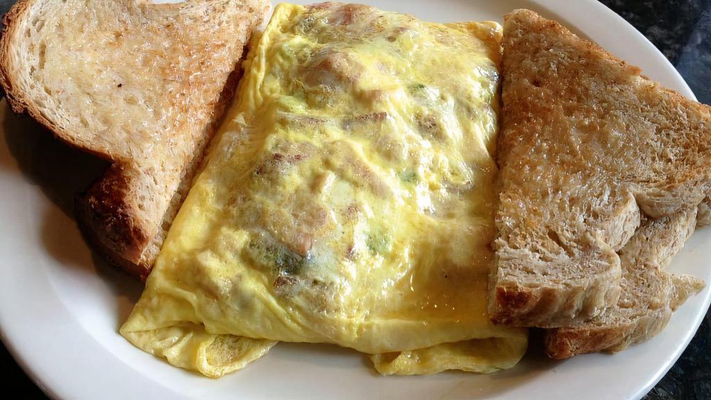 Egg Omelet · Three eggs with your choice of the following: bacon, sausage, ham, onion, peppers, olives, mushrooms, tomatoes and cheese. Served with toast. Replace toast for the pancake for an extra charge.