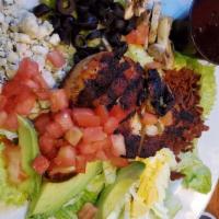 Cajun Cobb Salad · Mixed greens topped with mounds of crisp bacon, blue cheese crumbles, black olives, diced eg...