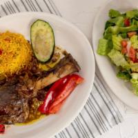 Lamb Shank · Roasted lamb in Moroccan sauce served with yellow rice and veggies.