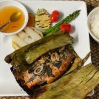 Grilled Salmon In Banana Leaves · Fresh Filet of salmon marinated with Thai herbs and spices, wrapped with banana leaves, gril...
