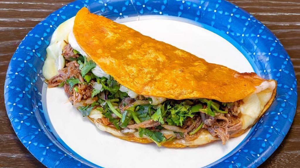 Quesataco · Big tortilla taco filled with cheese, shredded beef, cilantro and onion.