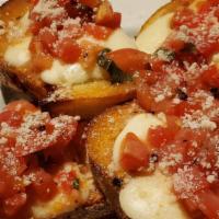 Traditional Bruschetta · Toasted Italian bread layered with sliced fresh mozzarella and marinated diced plum tomato.