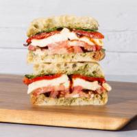 Mozarella Caprese · Fresh mozzarella with sliced tomato, roasted red peppers, mixed greens, basil pesto, and bal...